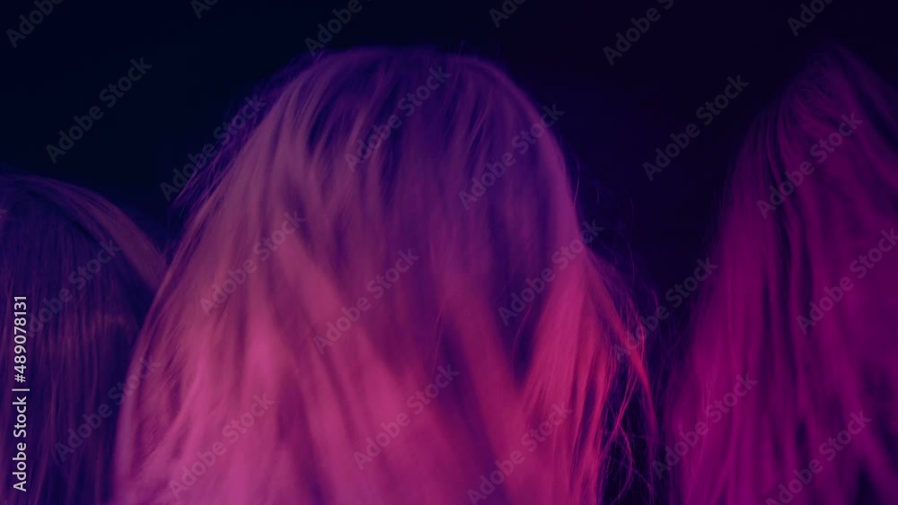 Metal Fans Shaking Their Heads In Colorful Lights
