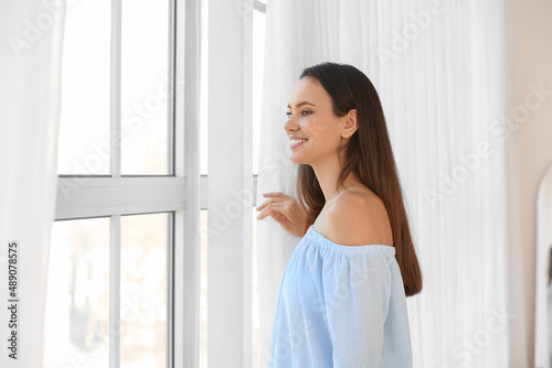 Pretty young woman near window