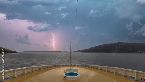 Navire de croisière en navigation. Vue de la proue avec un éclair pendant un orage. photo