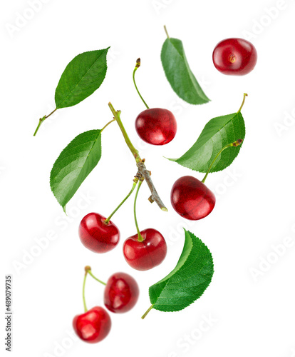 Cherry berries and green leaves isolated on white background.