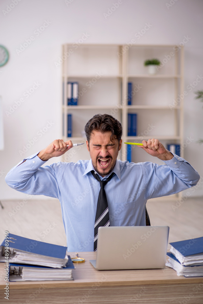 Naklejka premium Young male employee working in the office