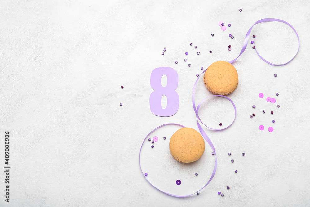 Composition with paper figure 8, sweet macaroons and ribbon on light background. International Women's Day celebration Composition with paper figure 8, sweet macaroons and ribbon on light background. International Women's Day celebration