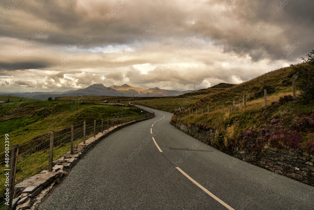 road in the mountains with dark moody sky