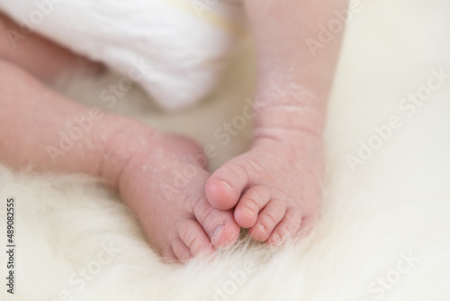 newborn baby sleeping on a lamb fur, small feet. High-quality photo