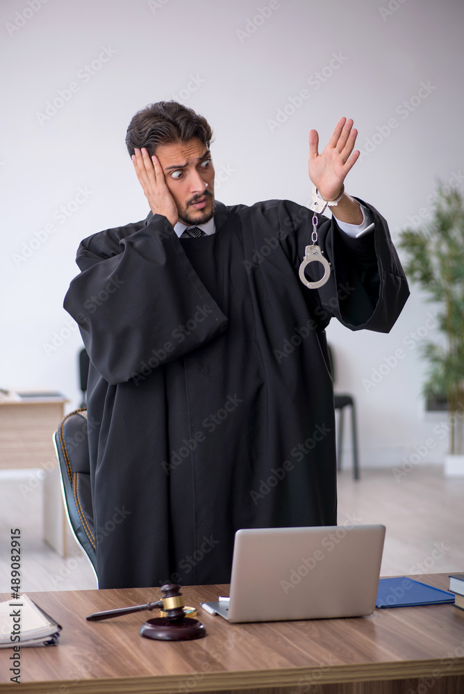 Young male judge in corruption concept Young male judge in corruption concept