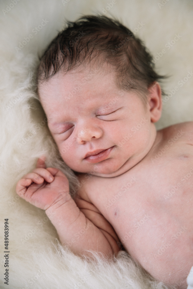 cute small newborn baby sleeping on a sheep fur. High quality photo