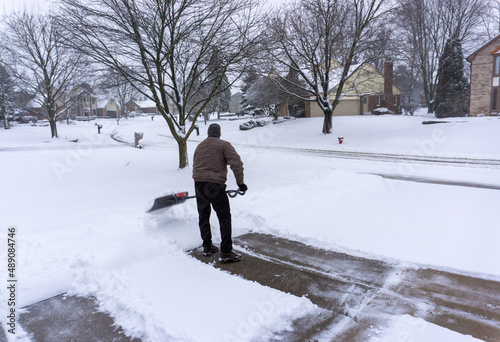 Old man shoveling driveway winter storm maintenance