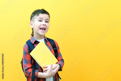 Child boy in glasses isolated on yellow paper wall. Great idea. Happy smiling schoolboy goes back to school.