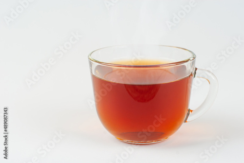 Transparent mug isolated on a white background. Mug with black tea close up.