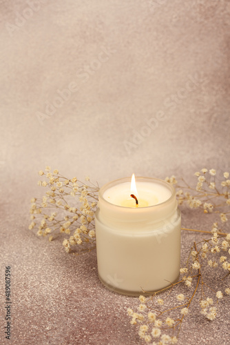 Soy wax candle in white glass on a beautiful background with copy space