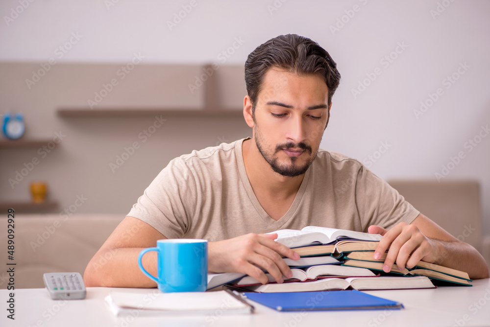 Young male student studying at home during pandemic