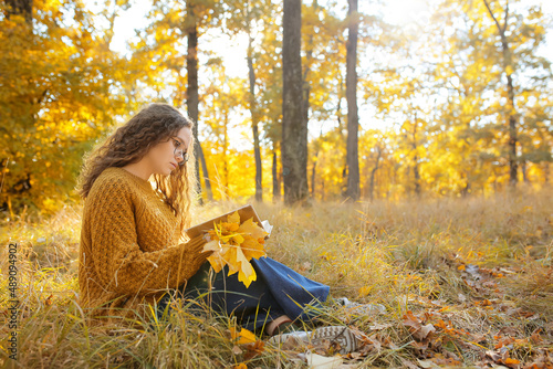 Woman reading book in autum...