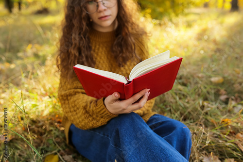 Woman reading book in autum...