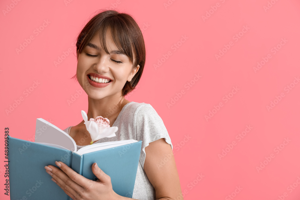 Beautiful young woman with book and flower on pink background Beautiful young woman with book and flower on pink background