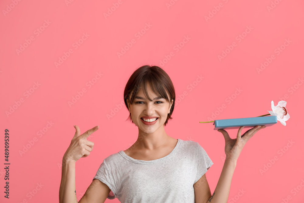 Beautiful young woman with book and flower on pink background Beautiful young woman with book and flower on pink background
