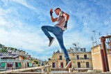 Fitness Model Fighter in Suit and Jeans doing Muay Thai Kickboxing and  Jumping on the roof