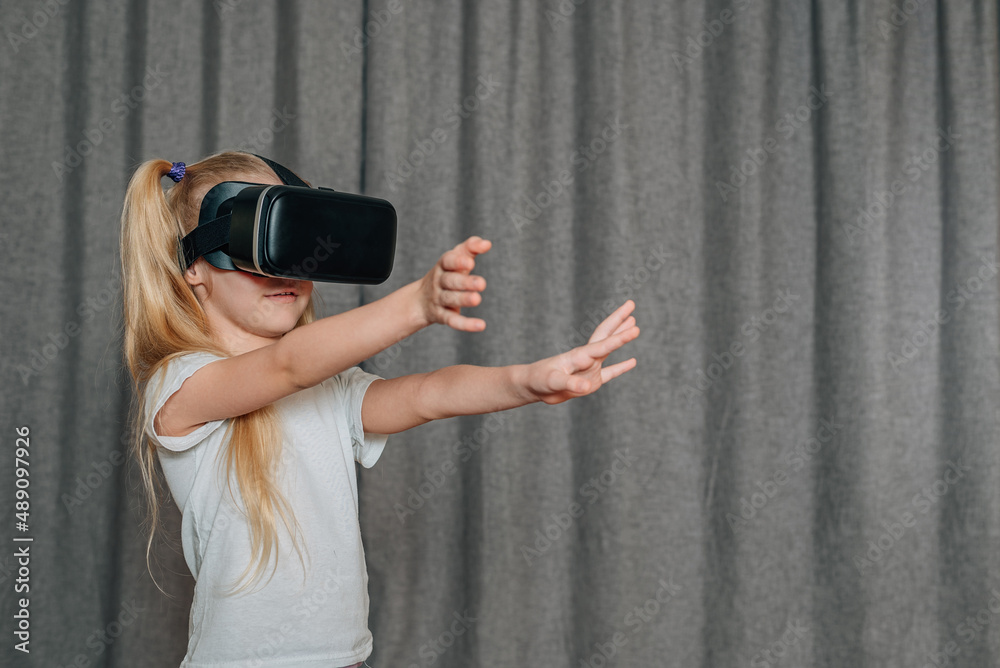 child girl at home in virtual reality VR glasses watching video, playing games. modern children are well versed in technological innovations. generation alpha child girl at home in virtual reality VR glasses watching video, playing games. modern children are well versed in technological innovations. generation alpha