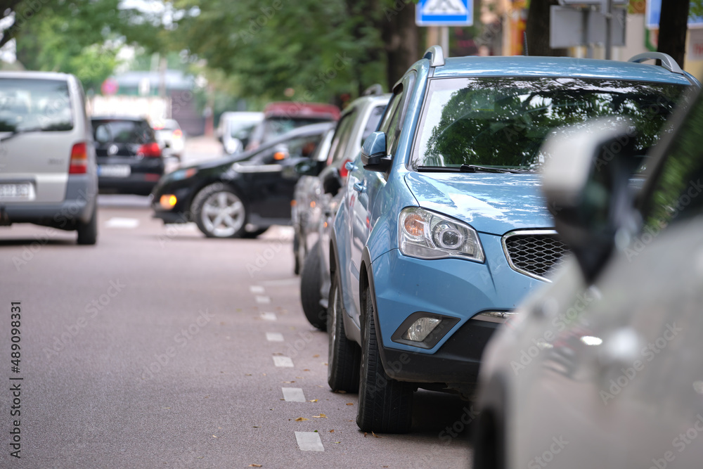 Cars parked in line on city street side. Urban traffic concept Cars parked in line on city street side. Urban traffic concept