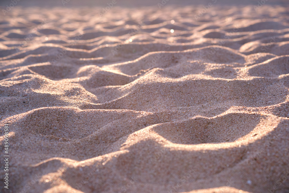Close up of clean yellow sand surface covering seaside beach illuminated with evening light. Travel and vacations concept Close up of clean yellow sand surface covering seaside beach illuminated with evening light. Travel and vacations concept