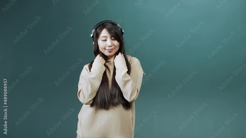 Funny positive girl with long dark hair dancing alone, moving to favorite music, enjoying leisure time