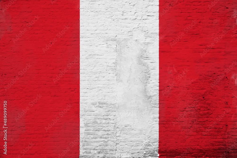 Full frame photo of a weathered flag of Peru painted on a plastered brick wall.