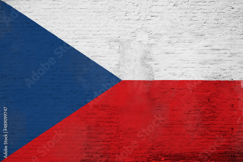 Full frame photo of a weathered flag of Czech Republic painted on a plastered brick wall.