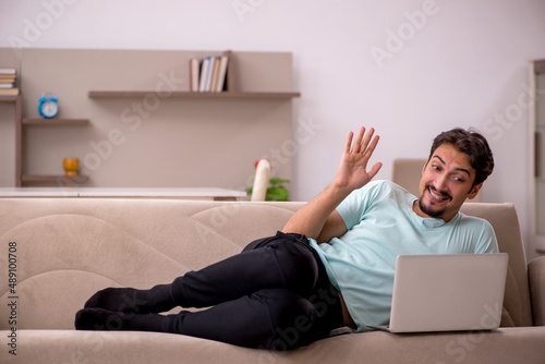 Young man sitting on the sofa with computer at home