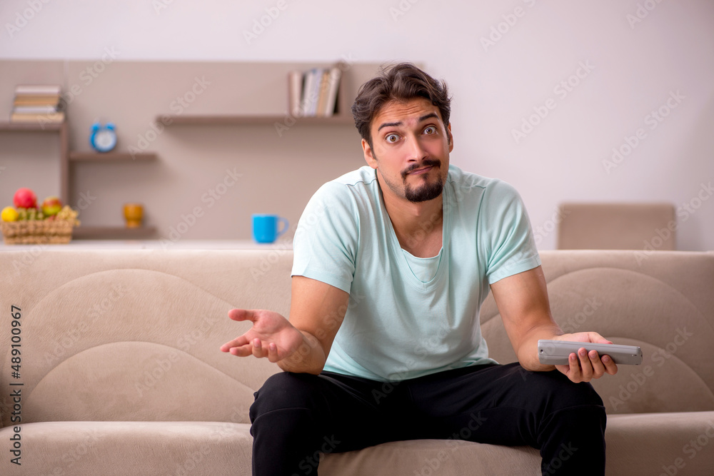 Fototapeta premium Young man watching tv at home