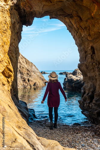 A young tourist girl with a hat in the Almanzora caves, Cala Peñon cut off a virgin and hidden beach in Almería. Mediterranean sea on the coast, Almería