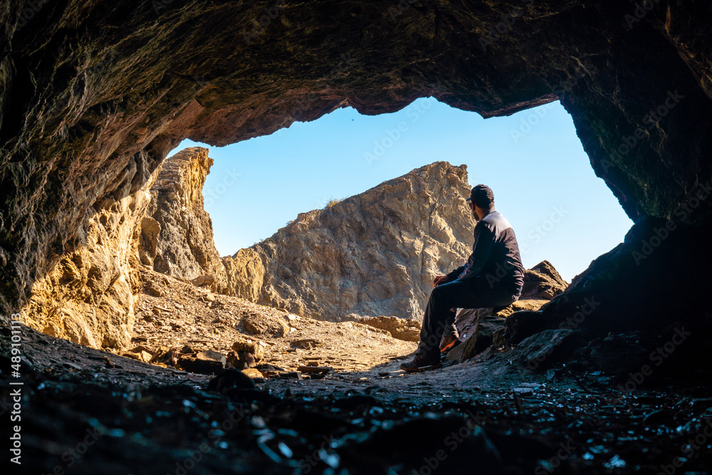 A young tourist sitting in the Almanzora caves, Cala Peñon cut off a virgin and hidden beach in Almería. Mediterranean sea on the coast, Almería