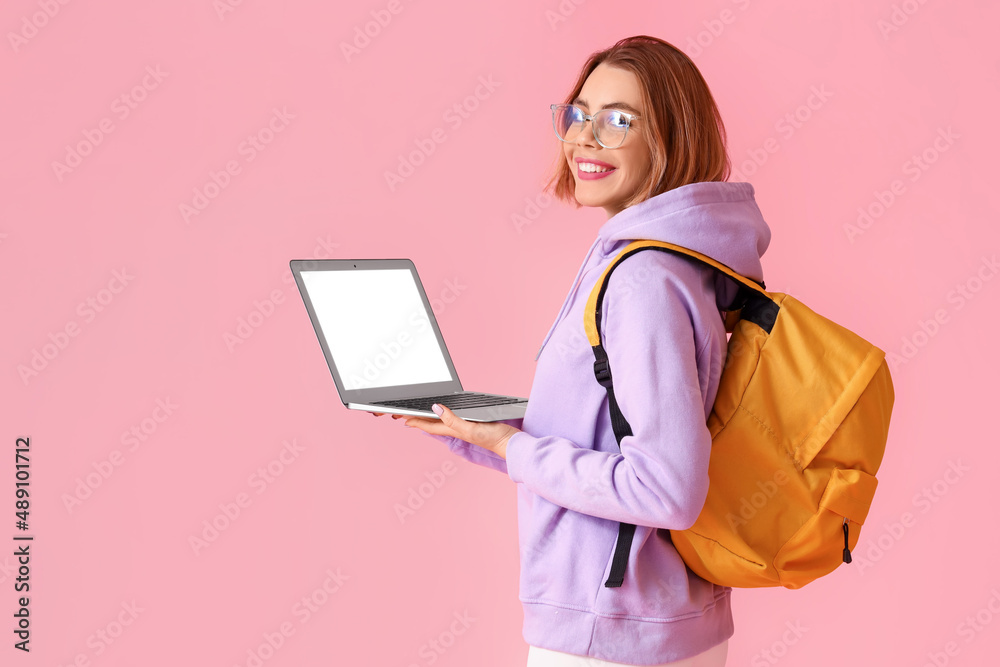 Female student with laptop on pink background Female student with laptop on pink background