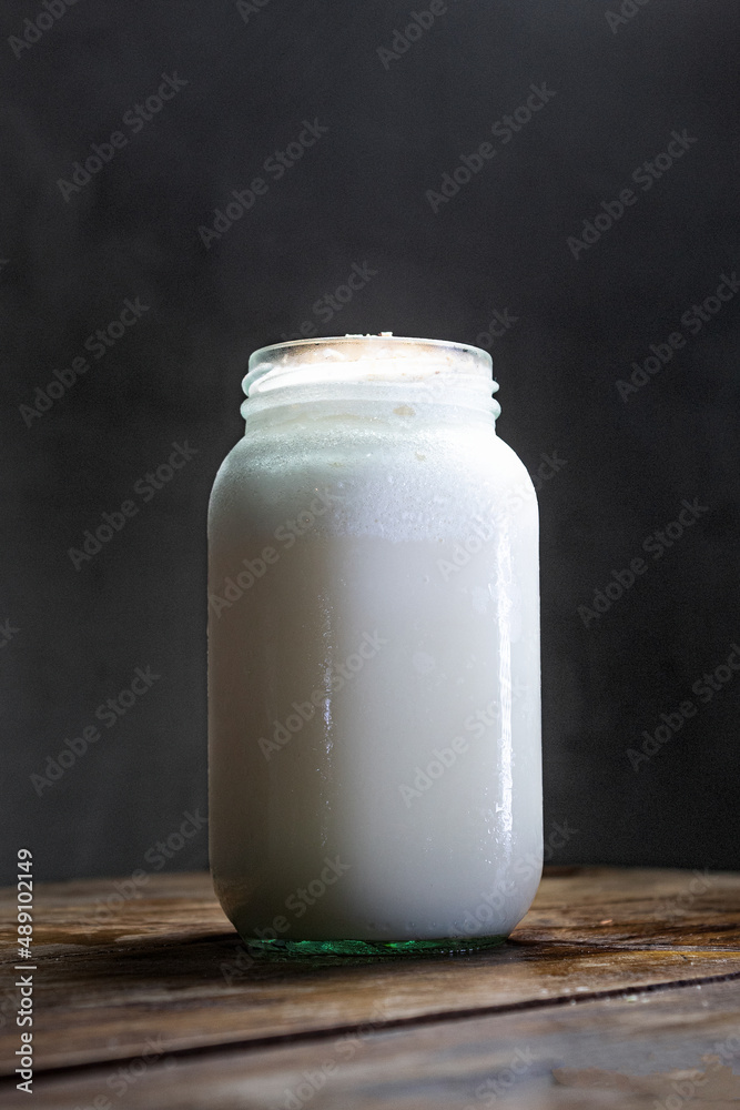 Limonada fría de coco sobre una mesa de madera con un fondo gris Limonada fría de coco sobre una mesa de madera con un fondo gris