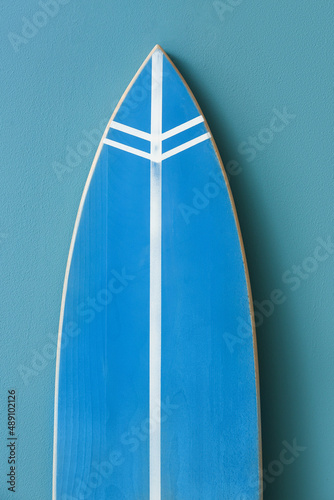 Modern surfboard near color wall