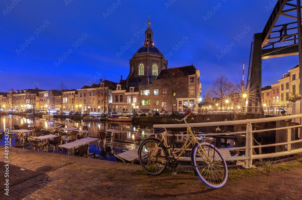 Fototapeta premium Beautiful old houses on the city embankment of Leiden at sunset.