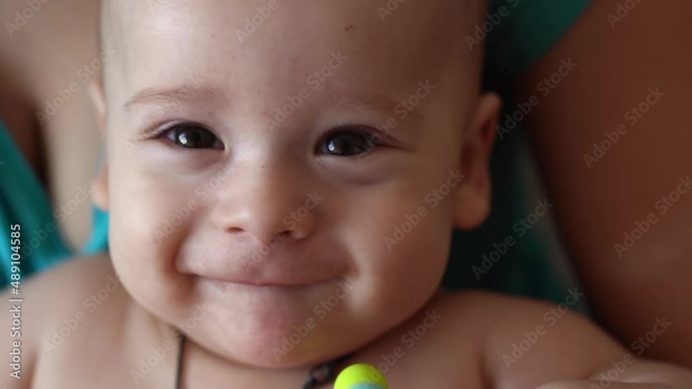 family, motherhood, people concept. close up Happy Mother little infant Baby with Teething Toy at Home. Young Mom with small smilling Newborn Child look at camera, pain pediatrics Healthcare Medicine