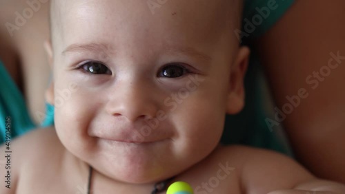 family, motherhood, people concept. close up Happy Mother little infant Baby with Teething Toy at Home. Young Mom with small smilling Newborn Child look at camera, pain pediatrics Healthcare Medicine