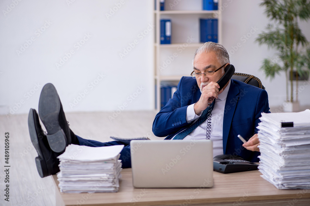 Fototapeta premium Old male employee and too much work in the office