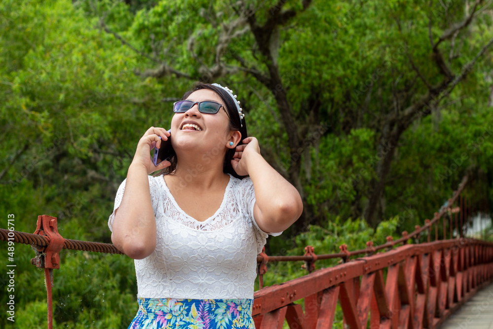 Una joven atractiva responde una llamada al aire libre, verde,naturaleza,arboles,bosque,celular, Una joven atractiva responde una llamada al aire libre, verde,naturaleza,arboles,bosque,celular,