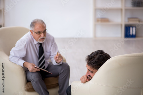 Young man visiting old psychologist