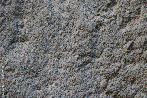 The gray texture of the stone wall of an old building or fence.