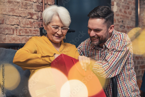 Fotografie Carrying middle-aged man prepared surprise gift for mature retired mother for Mother's Day celebration