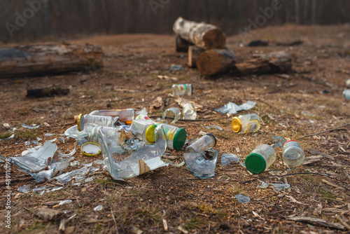 Illegal dump in a nature camp. Lots of broken jars on the ground in the countryside. The mess left by the campers.