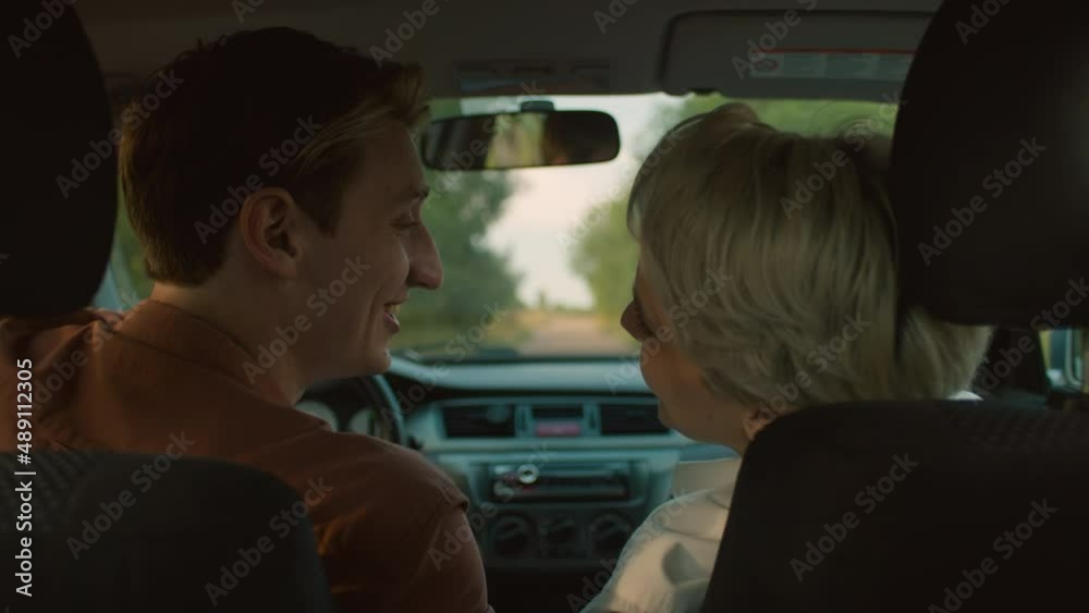 Young beautiful couple talk inside small car, authentic youth, woman with short hair and boyfriend have discussion and conversation on passenger and driver seat of a car Young beautiful couple talk inside small car, authentic youth, woman with short hair and boyfriend have discussion and conversation on passenger and driver seat of a car