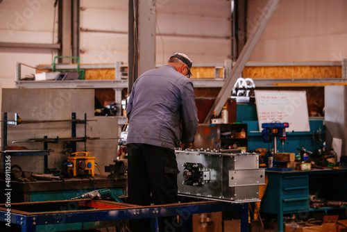 Factory workers assembling industrial equipment in workshop