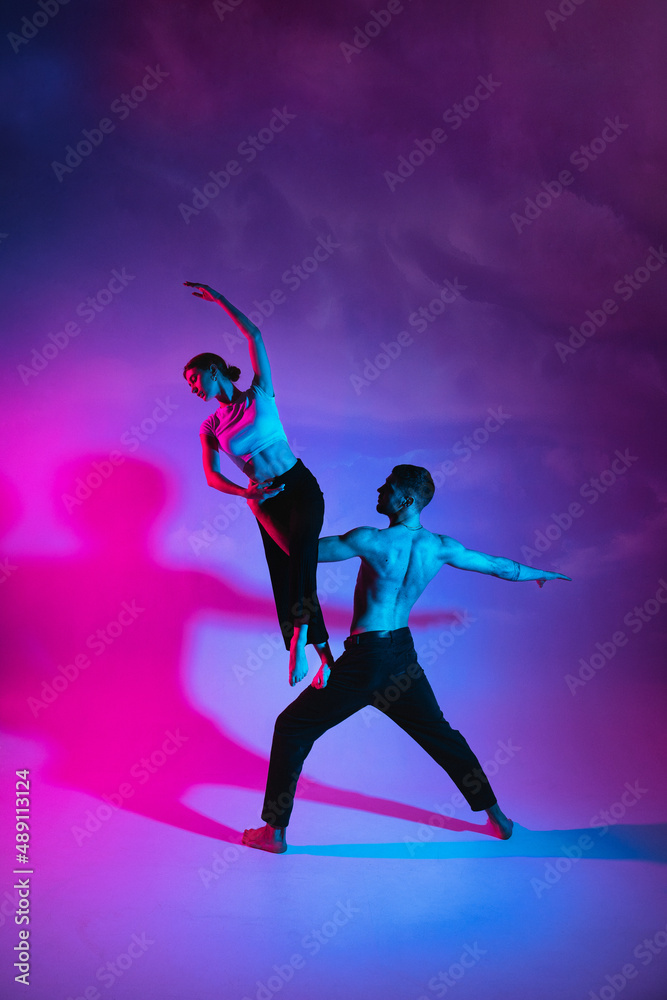 Gymnastics support. A strong man holds a girl with one hand Gymnastics support. A strong man holds a girl with one hand