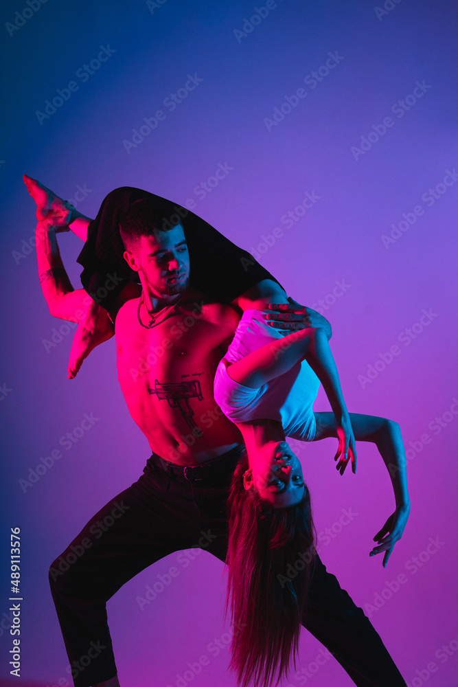 Support in gymnastics. Art. Body painting of a man and a woman, neon light Support in gymnastics. Art. Body painting of a man and a woman, neon light