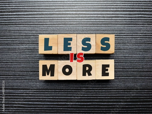 Phrase LESS IS MORE written on wooden cubes. photo