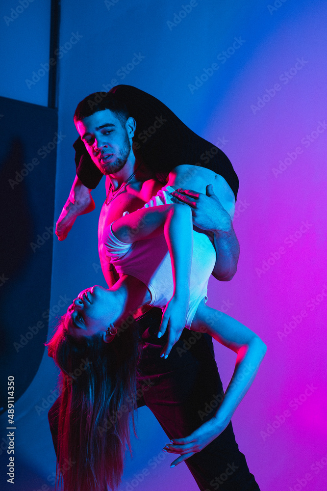 Support in gymnastics. A man holds a girl upside down, a concentrated girl