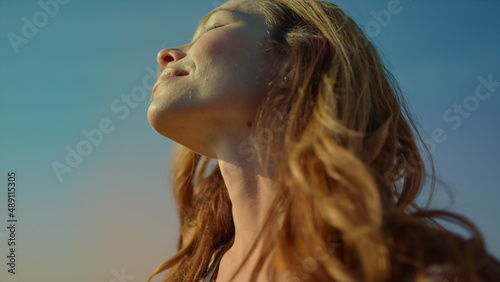 Closeup woman with camera enjoying sunlight in beautiful garden with wildflowers