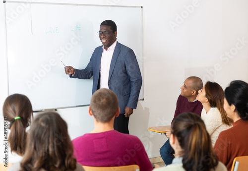 Teacher at university in front of chalkboard with multinational students © JackF
